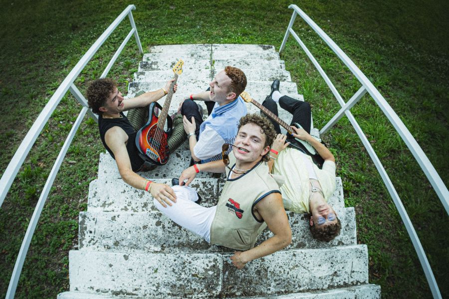Das Bild zeigt die vier Bandmitglieder von Udo West auf einer Steintreppe im Grünen sitzend. Sie sitzen sehr entspannt, zwei schauen sich an und einer liegt auf der Treppe. Sie haben alle blonde Locken. Zwei haben eine Gitarre dabei. Das Bild wurde von ob