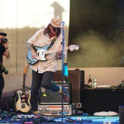 Gitarrist im Einsatz. Er hat das linke Bein angewinkelt und ist nach links gelehnt. Als würde er vom rechten aufs linke Bein wechseln.
